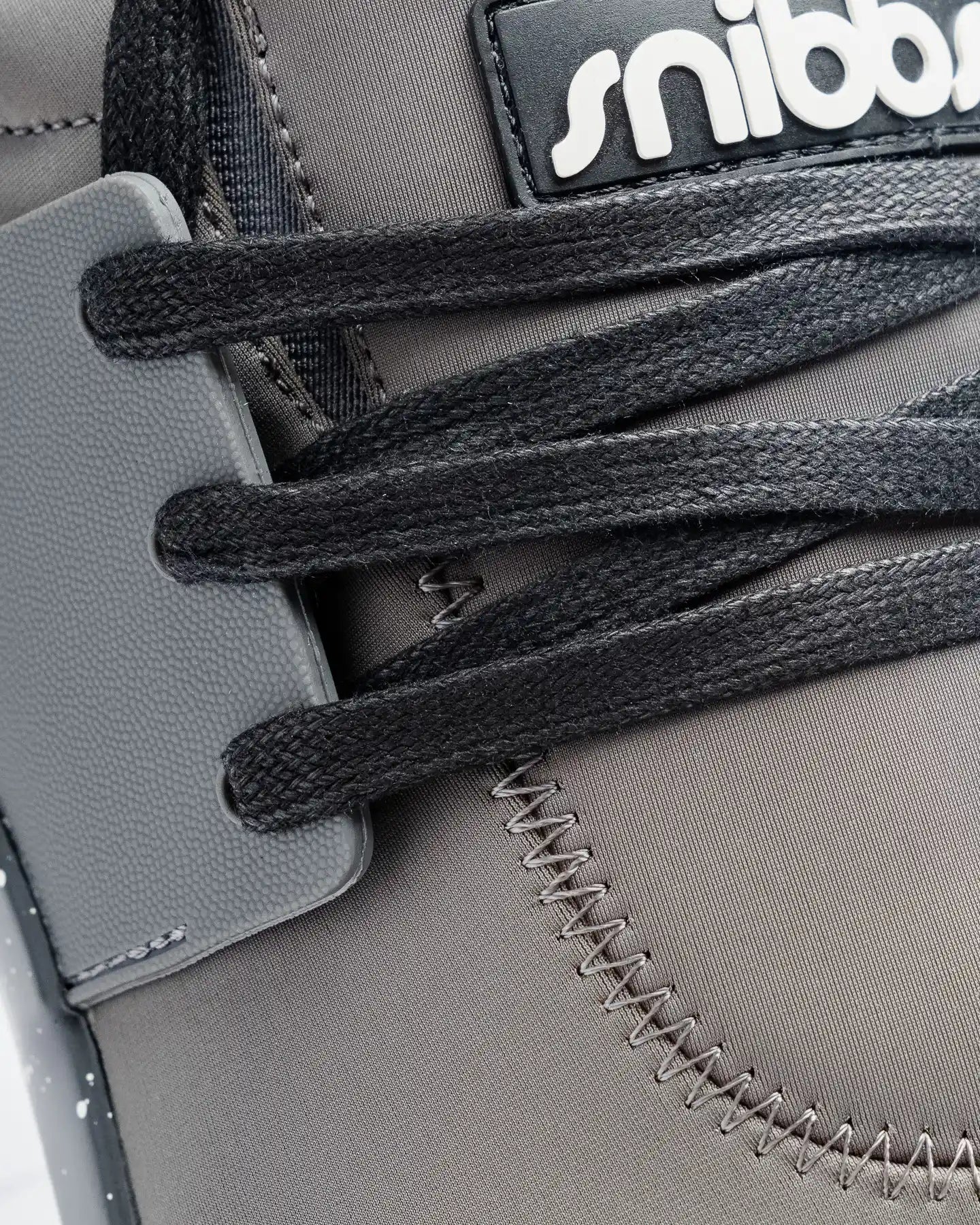 Close-up of Snibbs Spacecloud 2.0 - Charcoal: gray, slip-resistant work sneaker with black laces and white logo on the tongue.