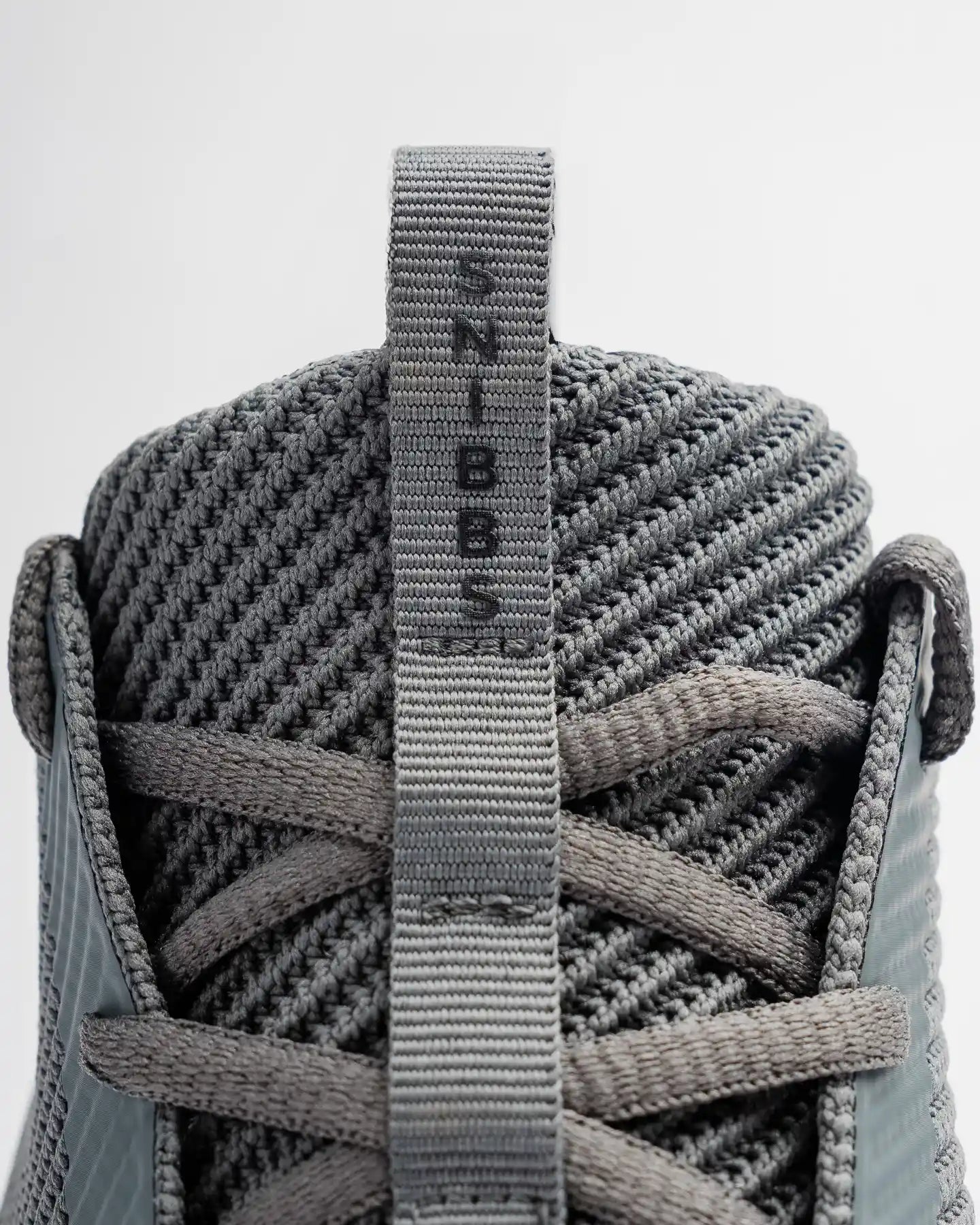 Close-up of the ROVR - Charcoal sneaker heel by Snibbs featuring a durable knit upper, slip-resistant sole, and branded pull tab.