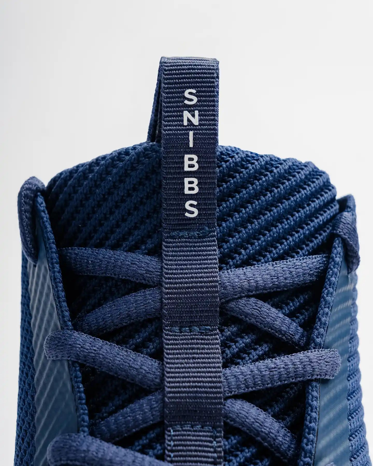 Close-up of the Snibbs ROVR - Nebula Blue: premium knit upper, visible laces, slip-resistant sole, and “SNIBBS” pull tab on tongue.