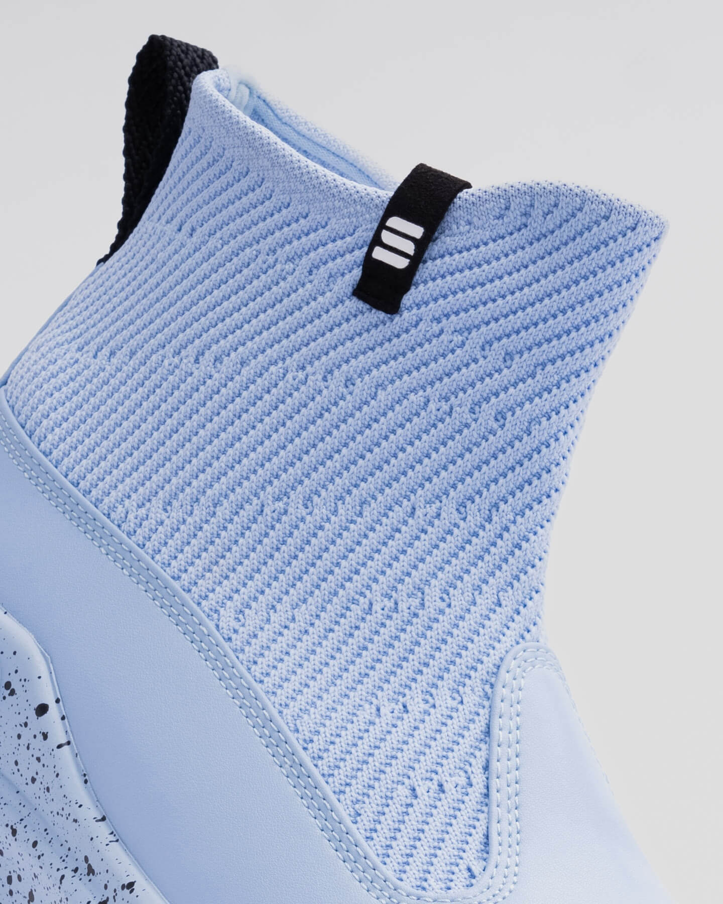 Close-up of the Snibbs Pro - Kentucky Blue: light blue knit high-top, breathable upper, speckled midsole, black pull tab with white logo.