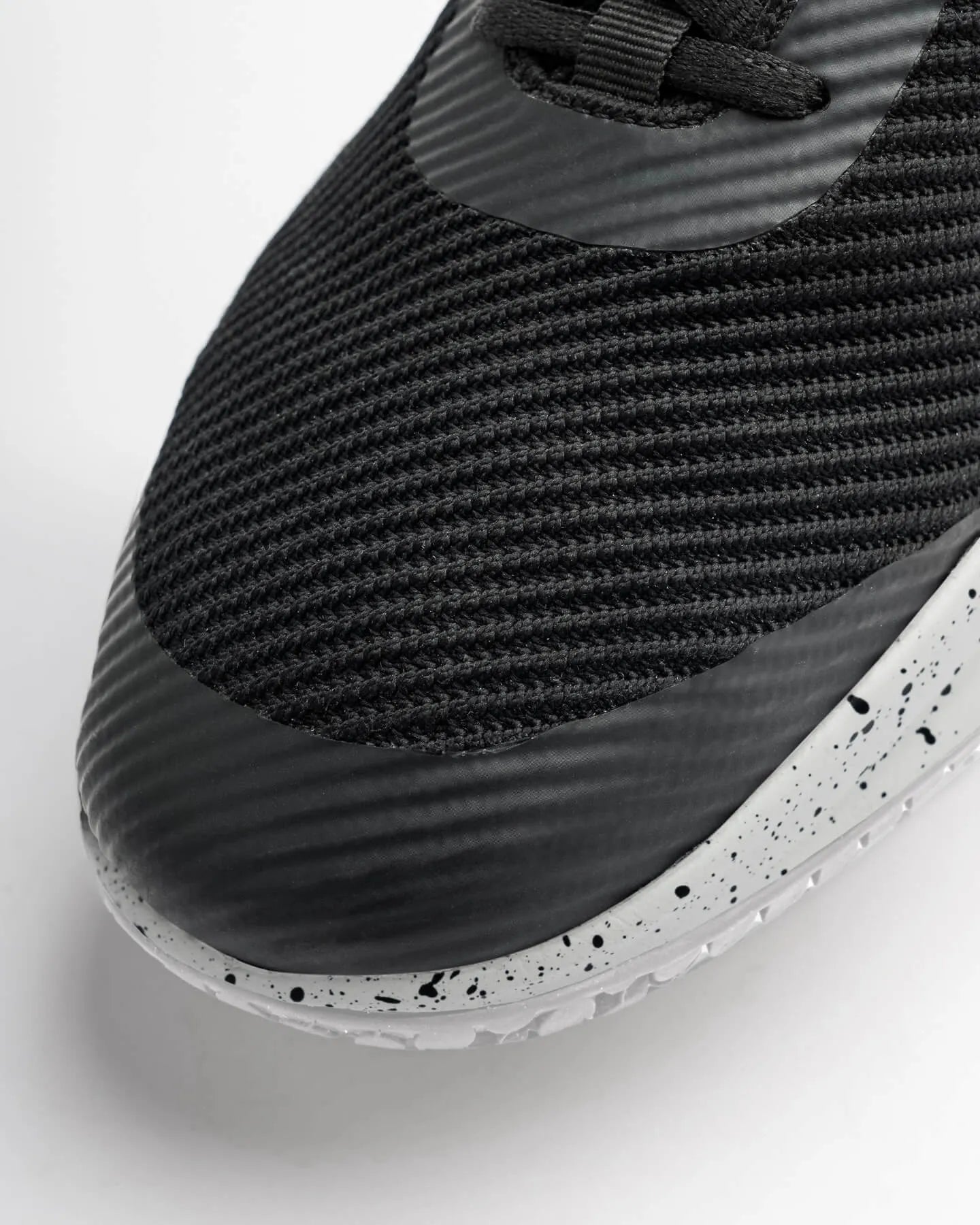 Close-up of the toe area of the Snibbs ROVR Salt and Pepper black, water resistant sneaker with a white speckled sole.