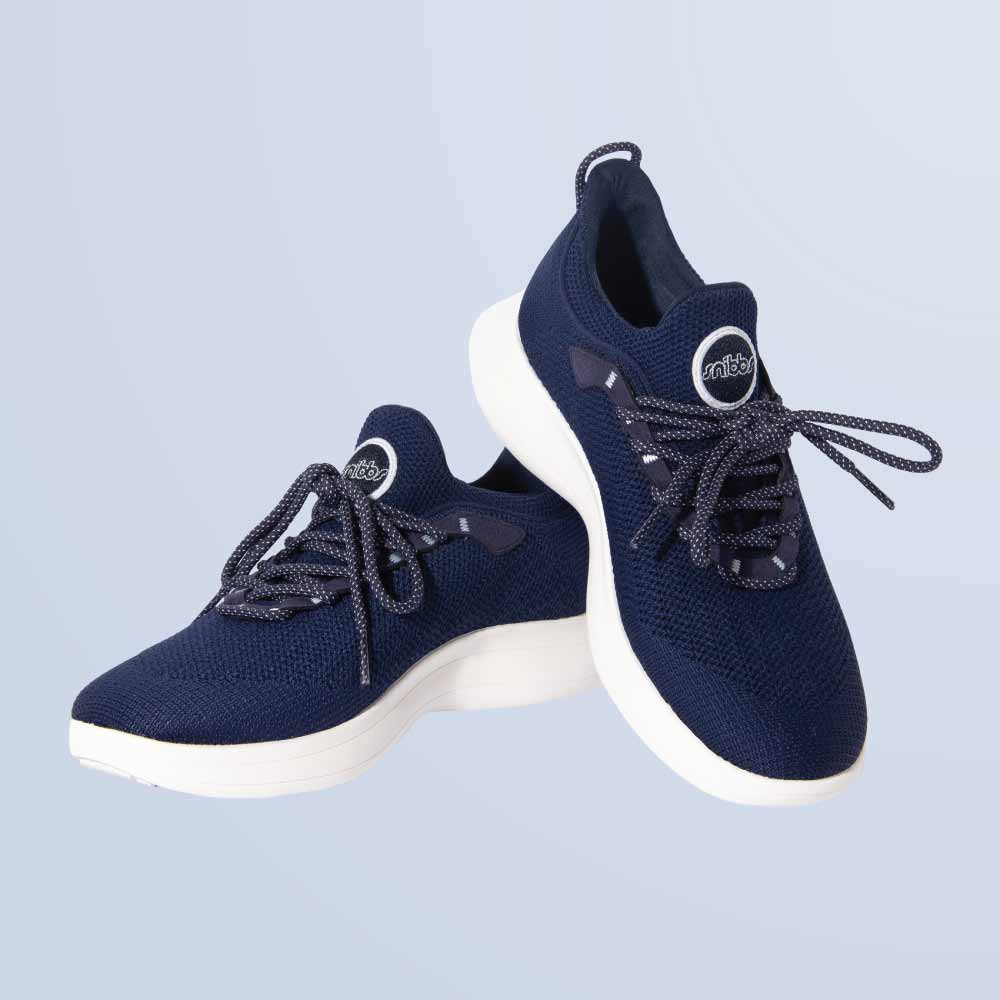 Snibbs Orbit - Maritime Blue: Navy lace-up shoes with breathable knit upper and white soles on a light blue background.