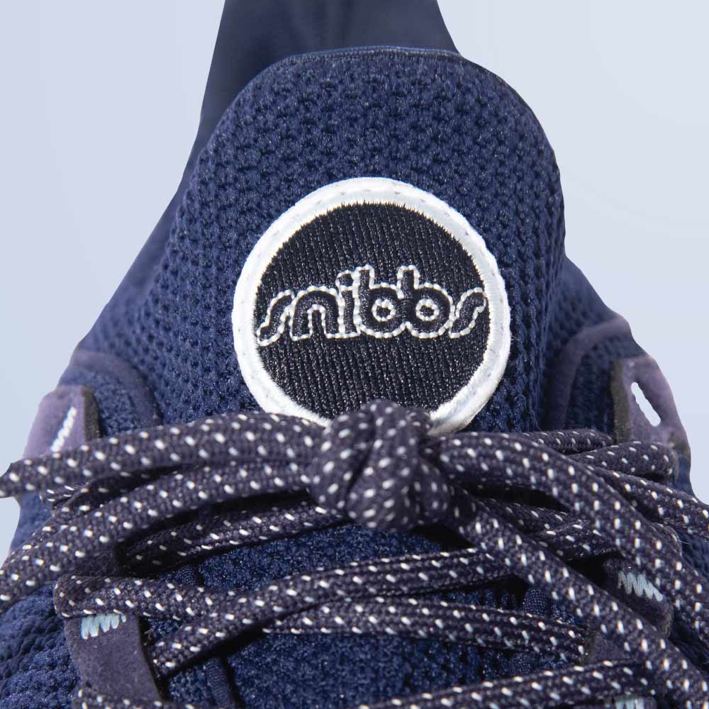 Close-up of the Snibbs Orbit - Maritime Blue sneaker, featuring patterned laces and a breathable knit upper for lightweight comfort.