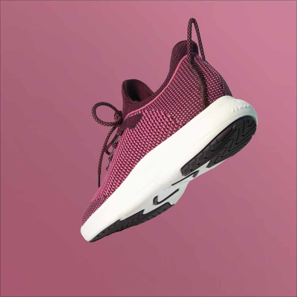The Snibbs Orbit - Wine Tasting sneaker, with a breathable knit upper and white sole, is shown from the heel and bottom on pink.