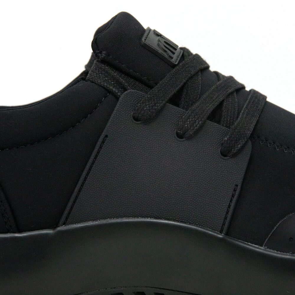 Close-up of the Men's Spacecloud - Eclipse Black work sneaker by Snibbs, highlighting the black laces, eyelets, and portions of the upper and sole. The shoe showcases a sleek, modern look crafted from matte black recycled materials with matching black lac