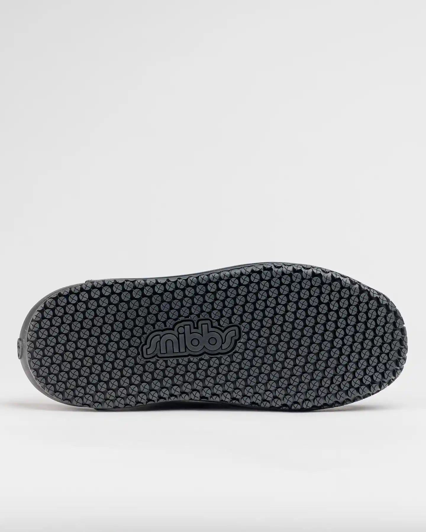 The image shows the sole of The Clog - Eclipse Black by Snibbs, with a dark gray textured non-slip design and “snibbs” embossed.