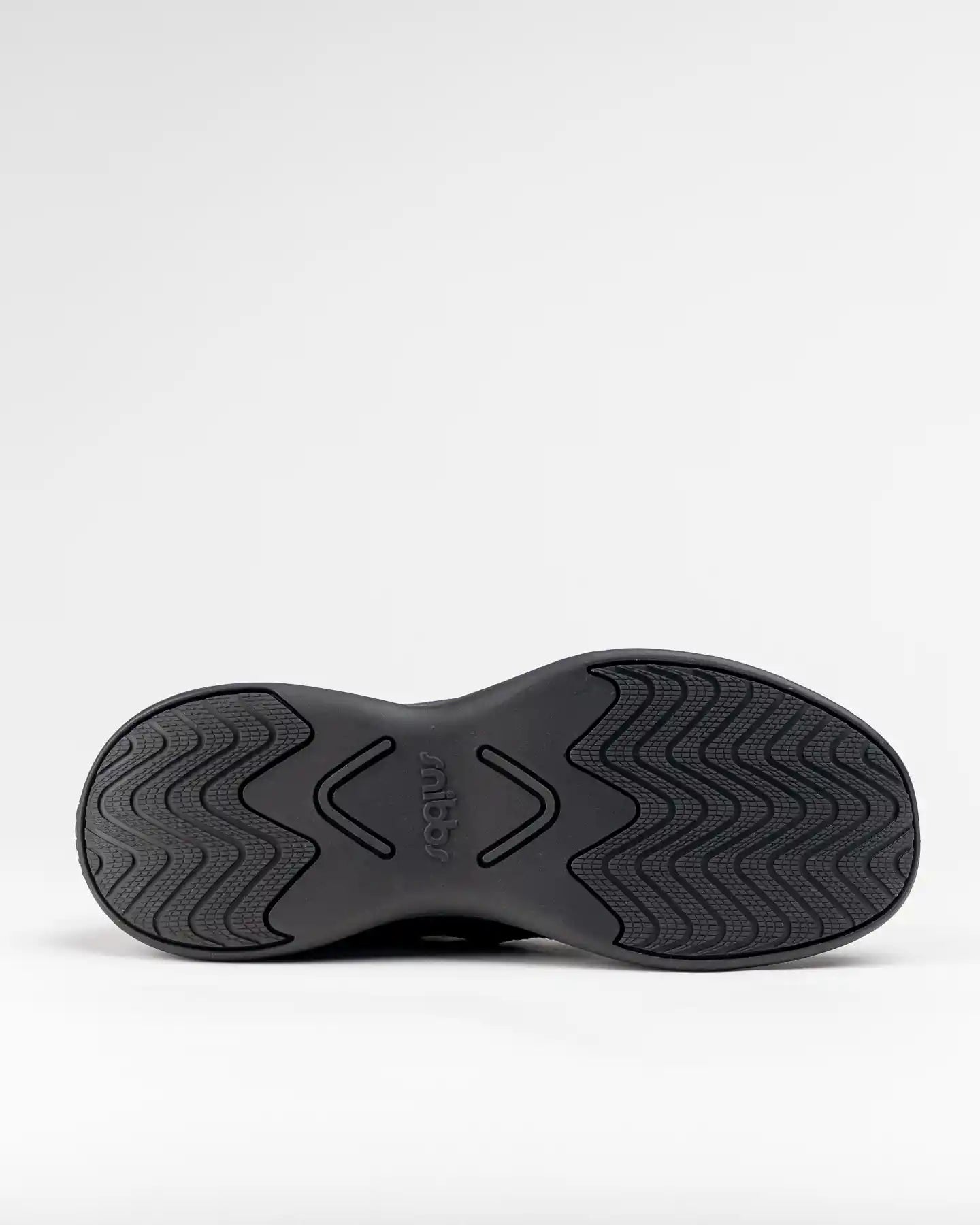Orbit - Eclipse Black sole facing up, wavy slip-resistant tread, "Snibbs" at center on white background.