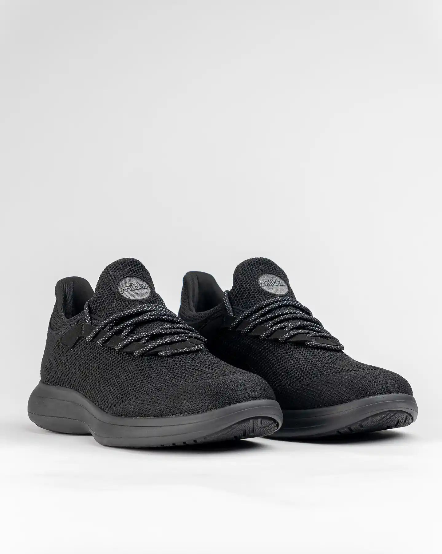 Snibbs Orbit - Eclipse Black sneakers with a breathable knit upper and black laces on a plain white background.