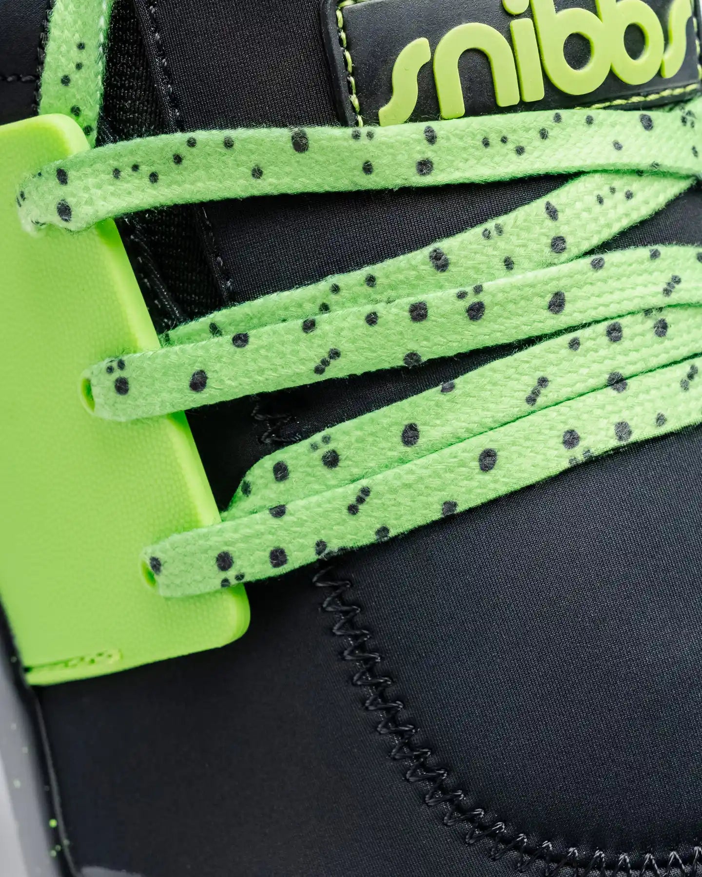 Close-up of Snibbs Spacecloud 2.0 - Lime Truck: black, water-resistant sneaker with lime speckled laces, green holder, logo detail.
