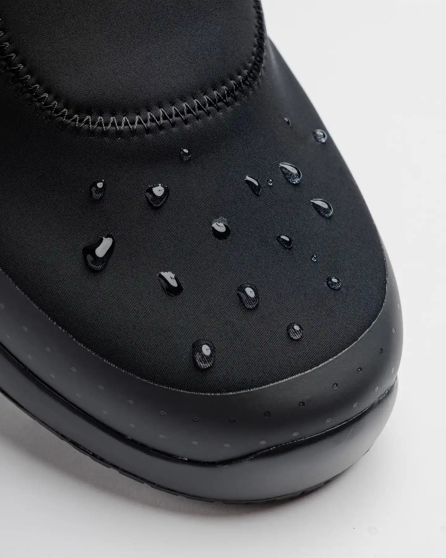 Close-up of Snibbs Spacecloud 2.0 - Eclipse Black, featuring slip-resistant and water-resistant material with water droplets visible.