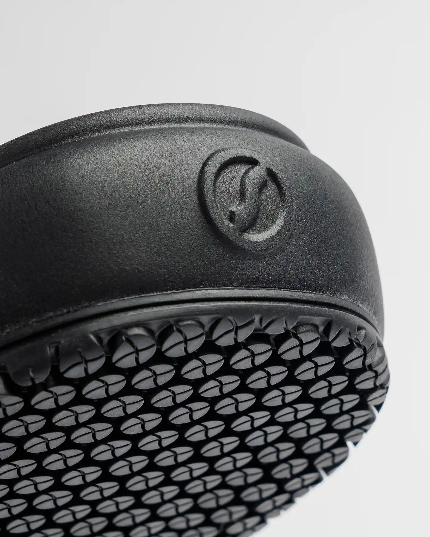 Close-up of The Clog - Eclipse Black by Snibbs shows its textured vegan sole and embossed circular logo.