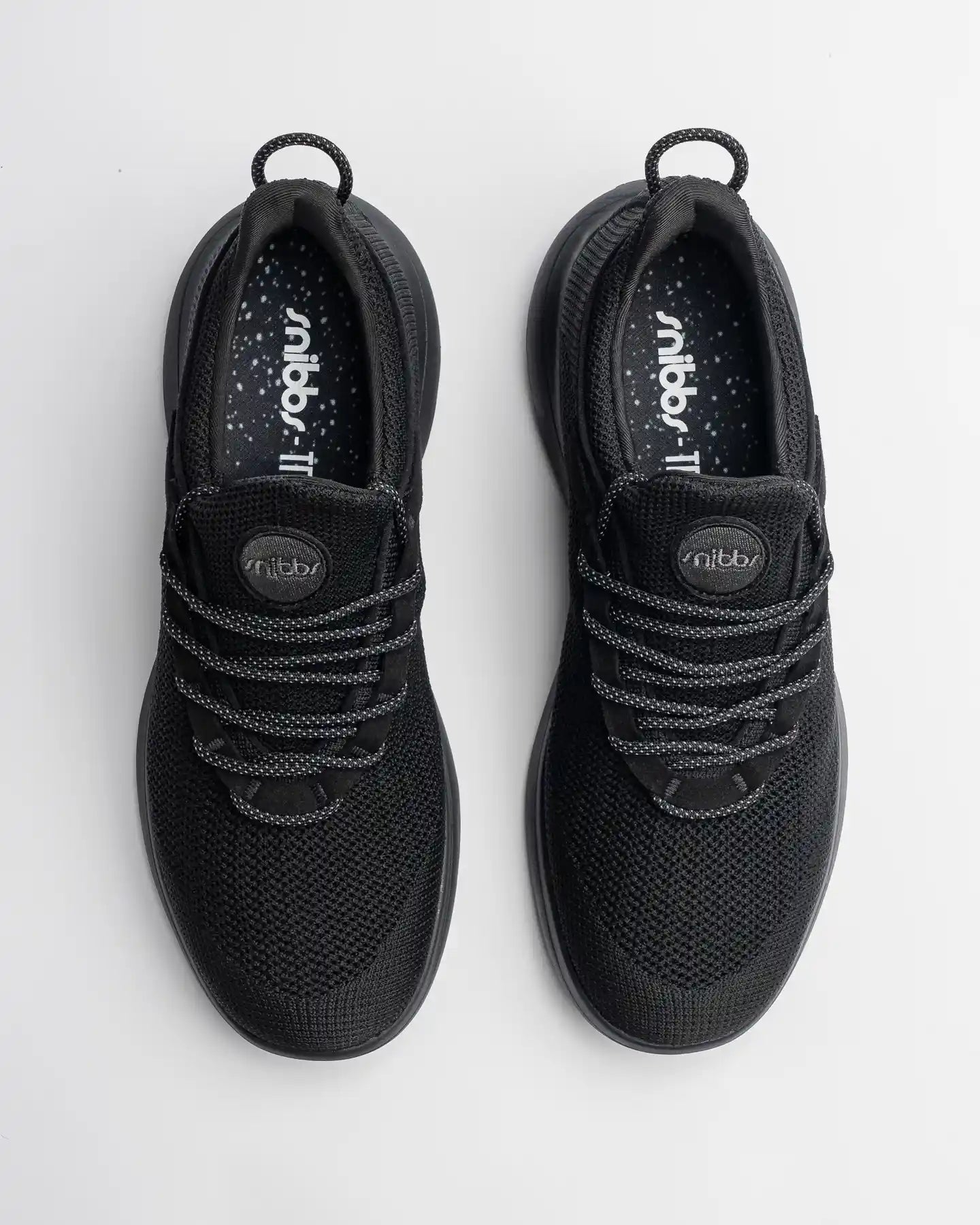 Orbit - Eclipse Black by Snibbs: lightweight, slip-resistant black athletic shoes with patterned laces, top view on white background.