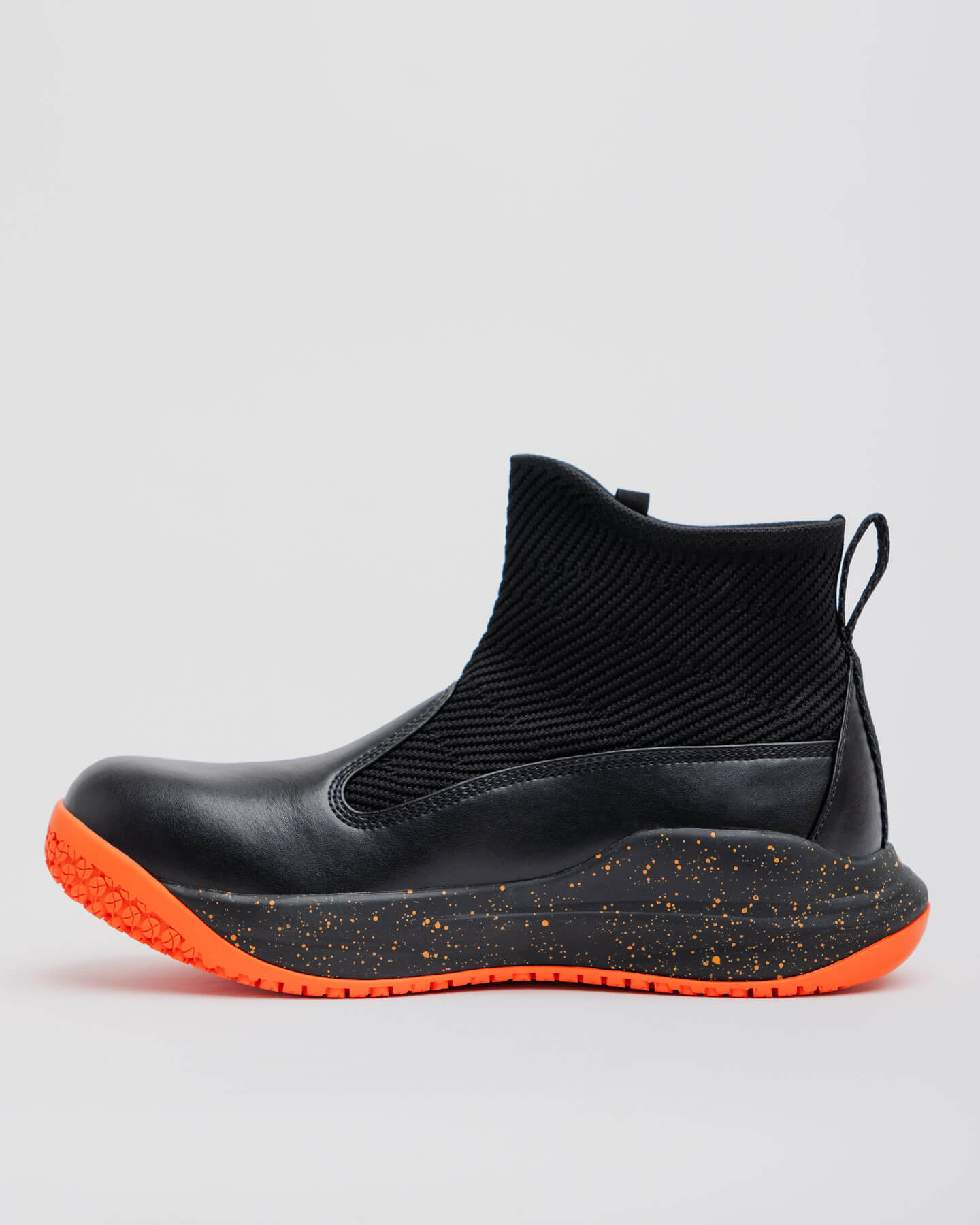 The Snibbs Pro - Tangerine is a black ankle boot with a knit upper, orange-speckled sole, and non-slip outsole, shown in profile.