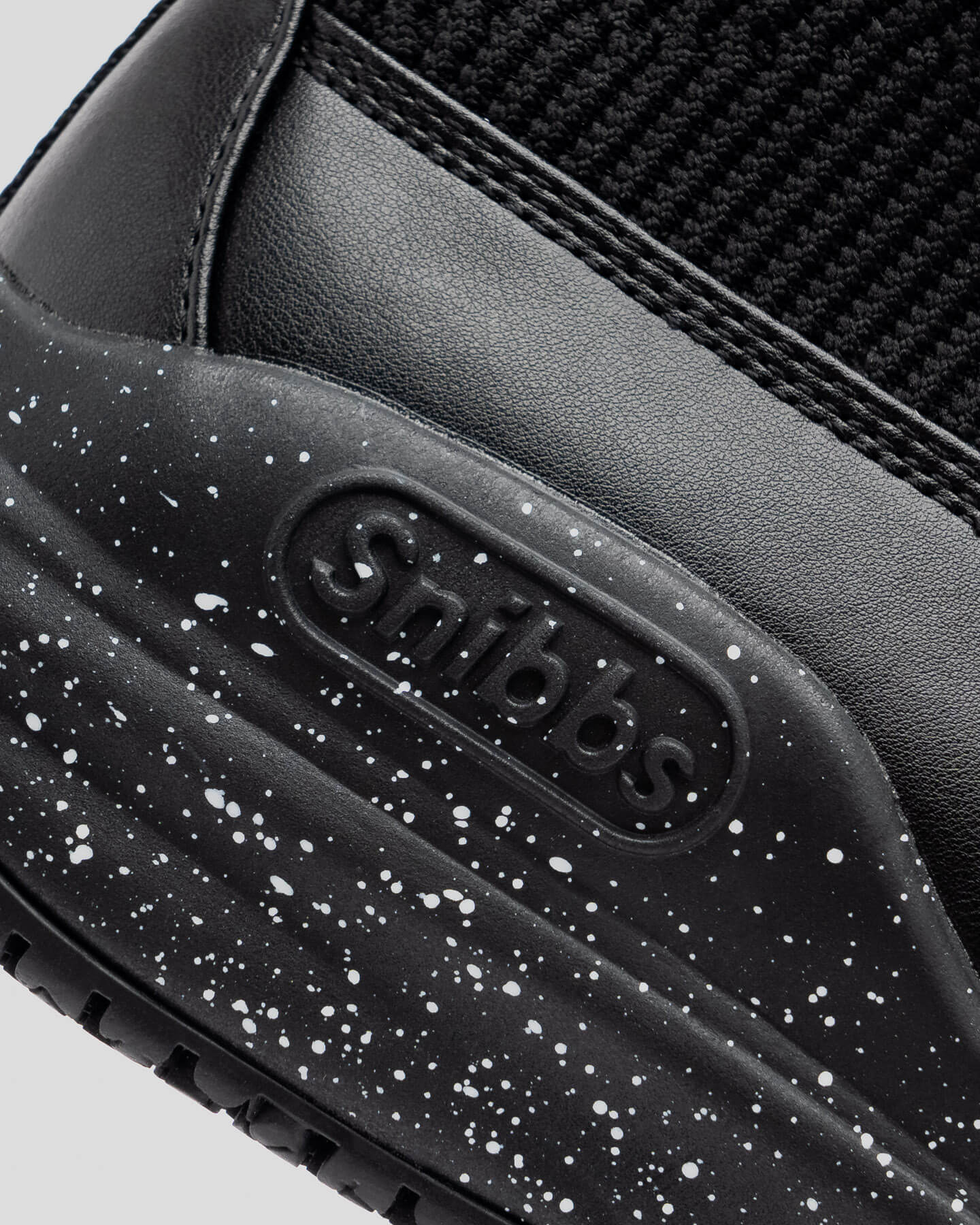 Close-up of Snibbs Pro - Black Speckle heel with logo, speckled midsole, and non-slip rubber outsole.