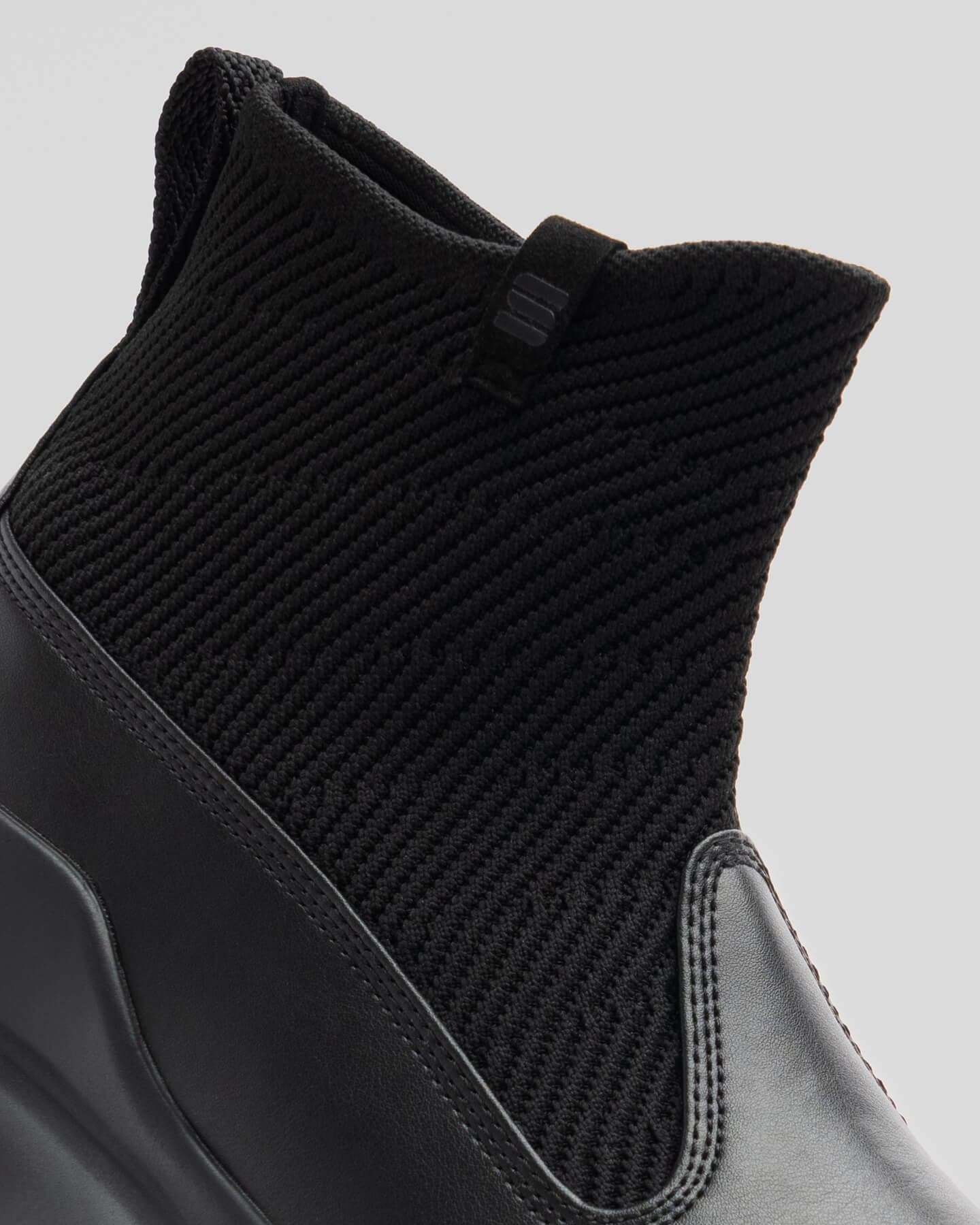 Close-up of Snibbs Pro - Eclipse Black: black ankle boot with knit upper, leather lower, pull tab, and easy slip-on design.