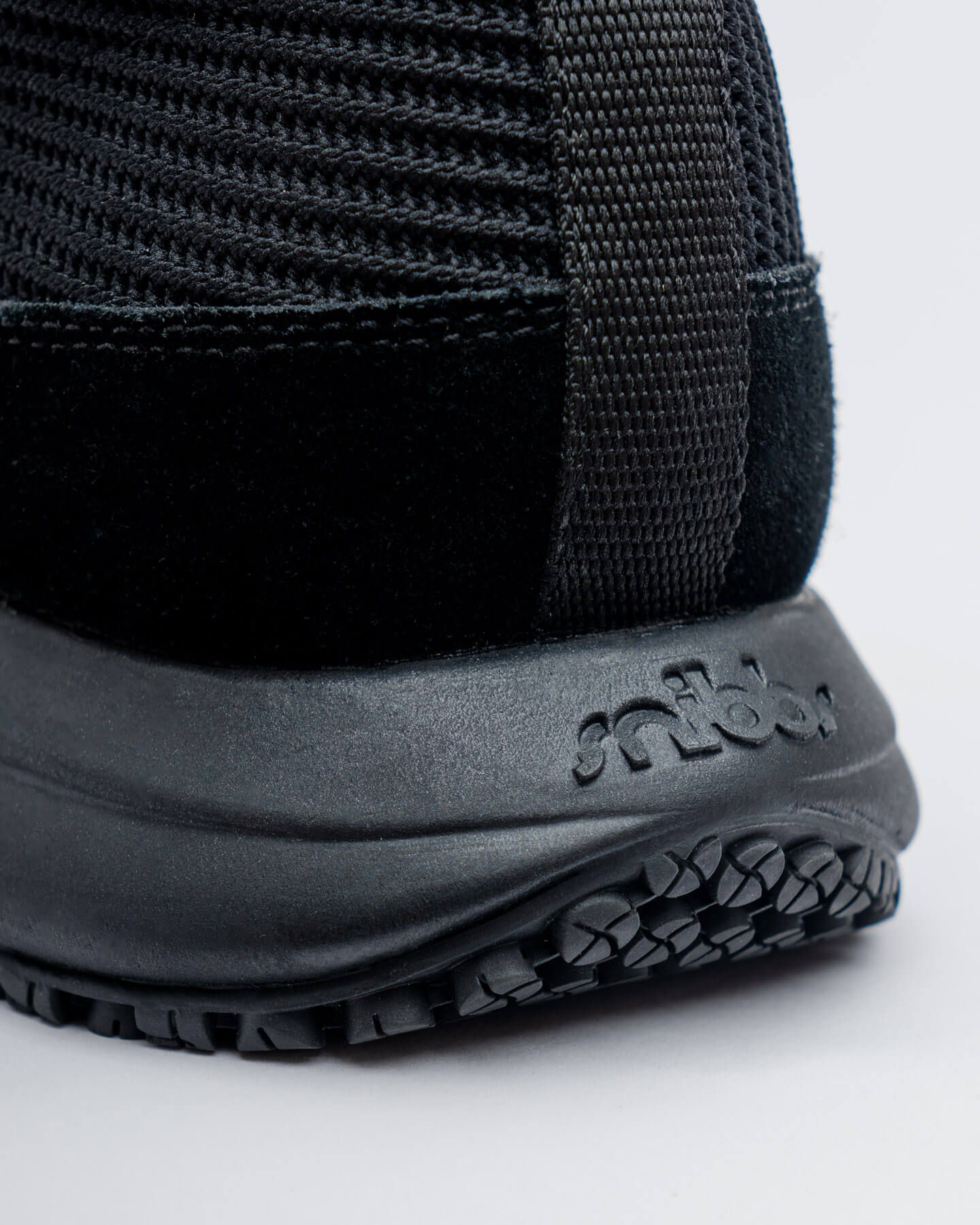Close-up of the ROVR Mid - Eclipse Black by Snibbs, featuring a slip-resistant outsole and visible stitching on the heel.
