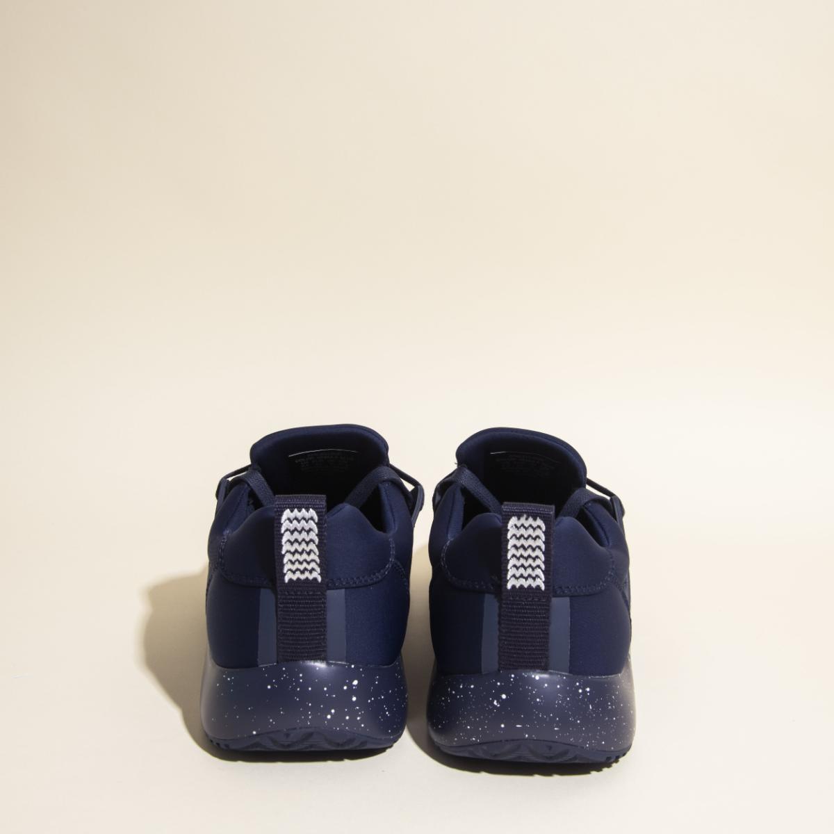 A pair of Snibbs Women's Spacecloud - Nebula Blue athletic shoes is shown from the back on a plain beige background, highlighting the white speckled soles and white zigzag-patterned pull tabs. These work sneakers are designed with slip-resistant soles for
