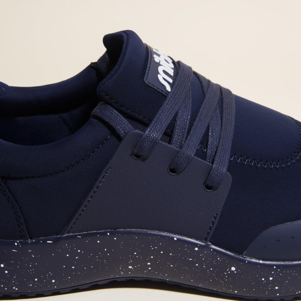 Close-up of the Snibbs Women's Spacecloud in Nebula Blue, featuring matching laces, a speckled white midsole, and a fabric upper. This vegan work sneaker is designed to be slip resistant, combining style and practicality for everyday wear.
